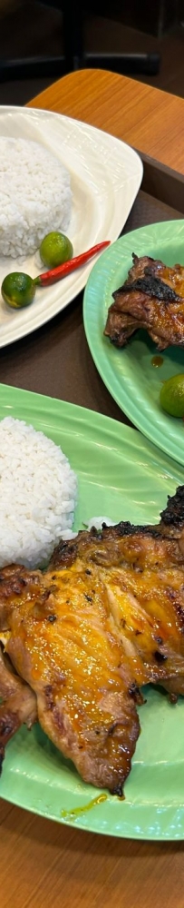 Grilled chicken and rice at Mang Inasa restaurant in the Philippines, topped with lime